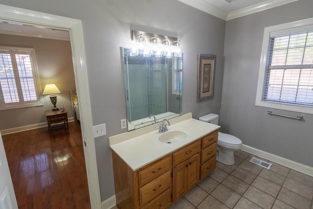 bathroom featuring crown molding, toilet, vanity, baseboards, and visible vents