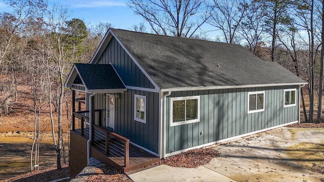 view of property exterior with a shingled roof and board and batten siding