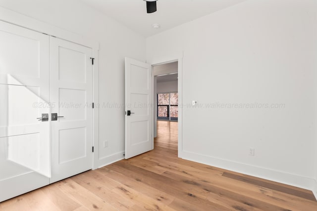 unfurnished bedroom with baseboards, ceiling fan, and light wood-type flooring