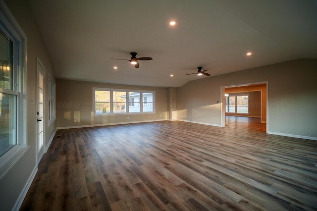 empty room with a ceiling fan, dark wood finished floors, and a wealth of natural light
