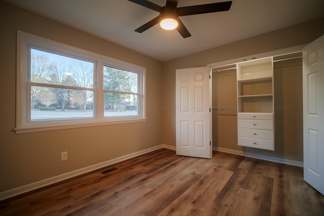 unfurnished bedroom featuring dark wood finished floors, baseboards, visible vents, and a closet