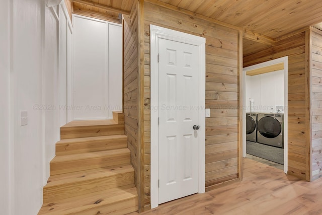interior space featuring wood ceiling, wooden walls, separate washer and dryer, and wood finished floors