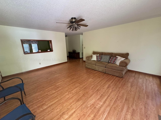 2354 Old Parrish Rd, Parrish, AL 35580 - living room featuring light wood-style flooring, a ceiling fan, a textured ceiling, and baseboards