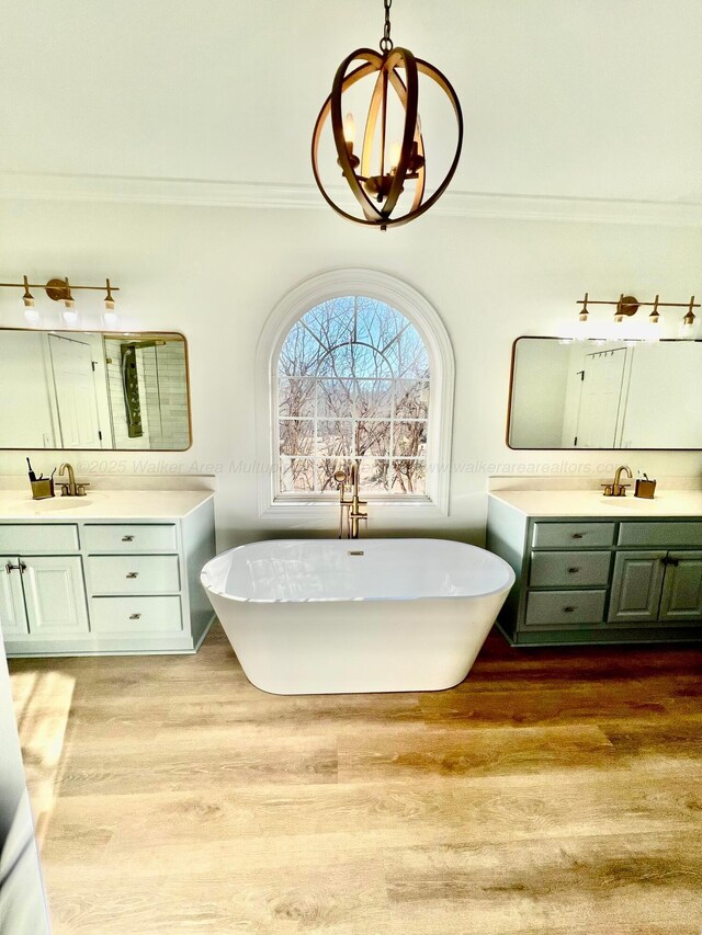 305 Chris Ln, Winfield, AL 35594 - bathroom with a freestanding bath, a sink, two vanities, and wood finished floors