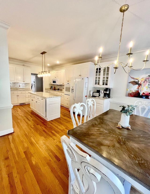 305 Chris Ln, Winfield, AL 35594 - kitchen with pendant lighting, light wood finished floors, a kitchen island, white cabinetry, and white appliances