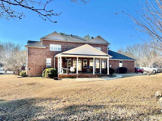 305 Chris Ln, Winfield, AL 35594 - back of property featuring a lawn, a patio area, and brick siding
