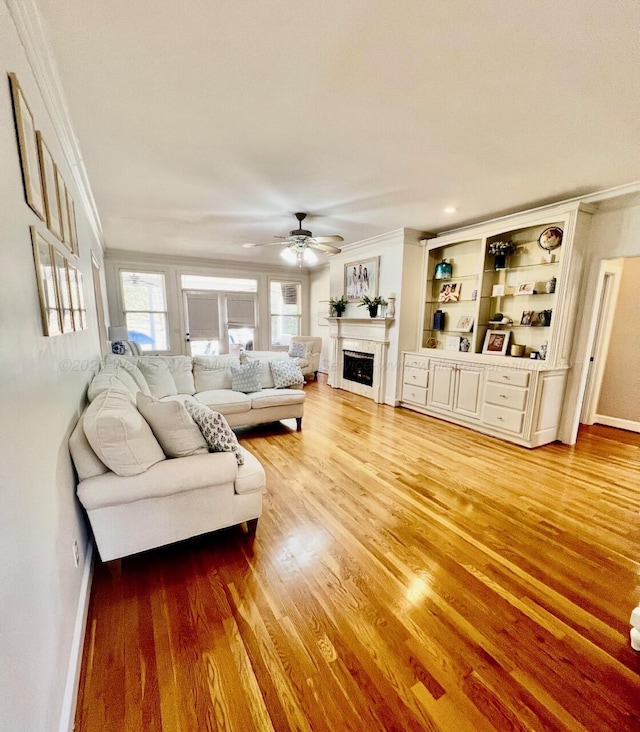 305 Chris Ln, Winfield, AL 35594 - living area featuring crown molding, baseboards, a fireplace, ceiling fan, and light wood-style floors