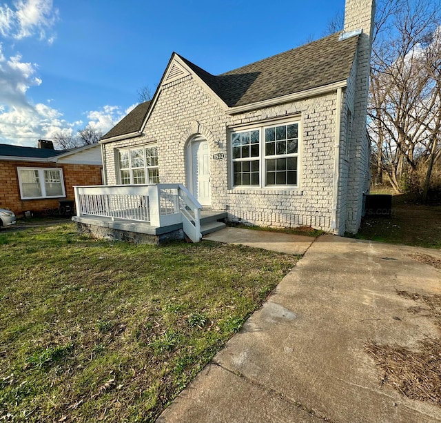 1532 SW Bay Ave, Birmingham, AL 35211 - view of front of house featuring a chimney, brick siding, a front lawn, and a wooden deck