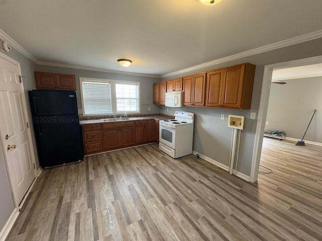 kitchen with a sink, ornamental molding, brown cabinetry, and white appliances