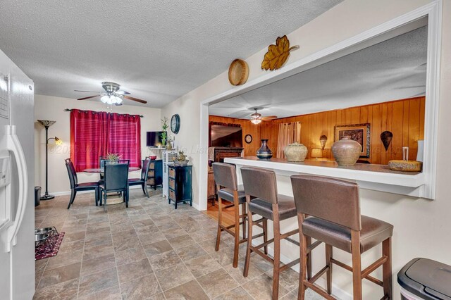 2555 Shady Rd, Adamsville, AL 35005 - dining room with a ceiling fan, wooden walls, and a textured ceiling