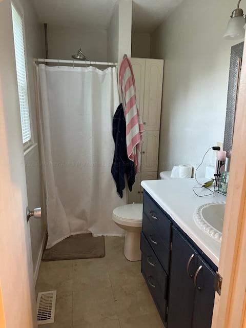bathroom with visible vents, toilet, vanity, and a shower with shower curtain