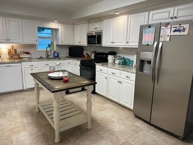kitchen with white cabinetry, a sink, and stainless steel appliances