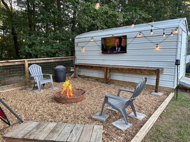 exterior space with an outdoor fire pit, an outdoor structure, and a garage