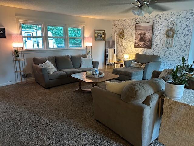 living room with carpet, baseboards, wallpapered walls, and a ceiling fan