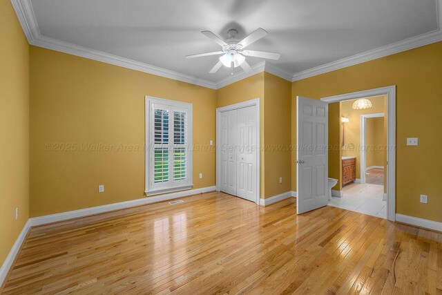 5746 Old Birmingham Hwy, Jasper, AL 35501 - unfurnished bedroom featuring light wood-style floors, ornamental molding, a ceiling fan, and a closet