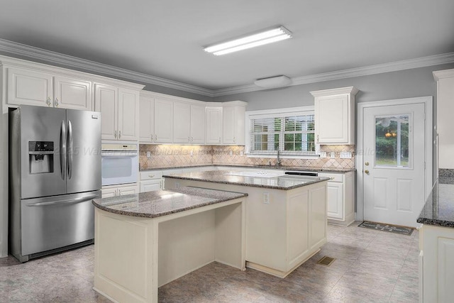 5746 Old Birmingham Hwy, Jasper, AL 35501 - kitchen featuring stainless steel fridge, white oven, a kitchen island, dark stone counters, and backsplash
