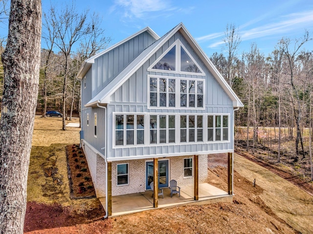556 Sipsey Rock Rd, Crane Hill, AL 35053 - rear view of house featuring brick siding, board and batten siding, and a patio area