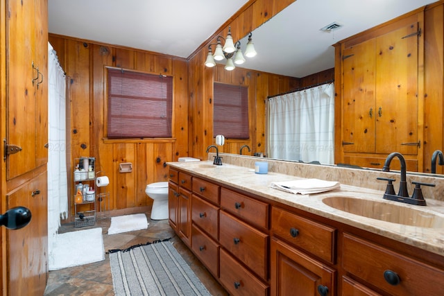 bathroom with curtained shower, vanity, toilet, and wooden walls