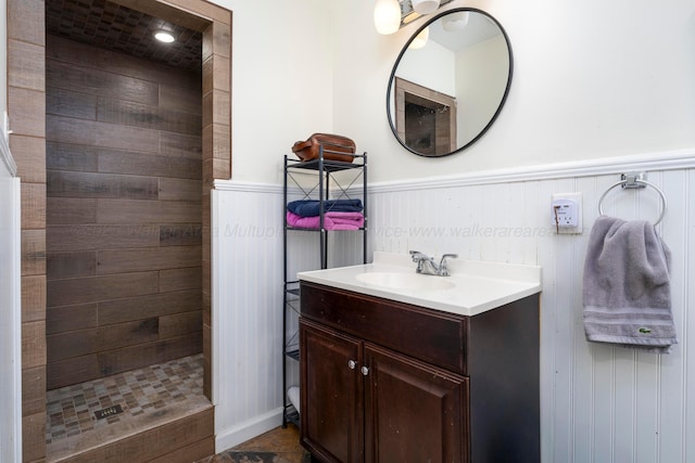 bathroom with tiled shower and vanity