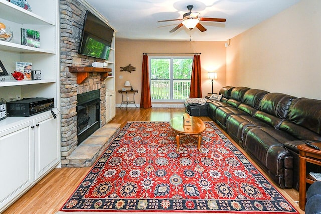 1528 Sipsey Rd, Double Springs, AL 35553 - living room with light wood-style flooring, a ceiling fan, and a stone fireplace