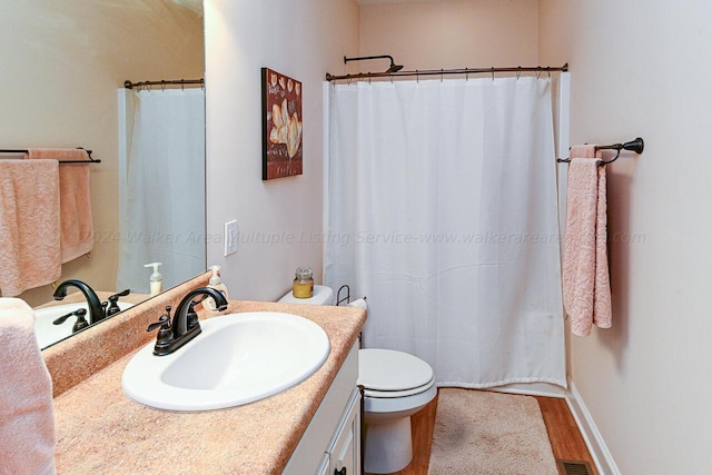 1528 Sipsey Rd, Double Springs, AL 35553 - bathroom featuring toilet, curtained shower, vanity, wood finished floors, and baseboards