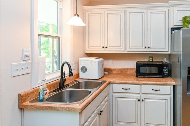 1528 Sipsey Rd, Double Springs, AL 35553 - kitchen featuring light countertops, stainless steel fridge, a sink, black microwave, and hanging light fixtures
