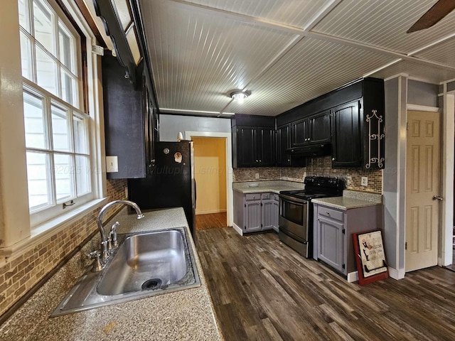 2701 N Airport Rd, Jasper, AL 35504 - kitchen featuring stainless steel range with electric stovetop, dark wood-type flooring, under cabinet range hood, a sink, and freestanding refrigerator