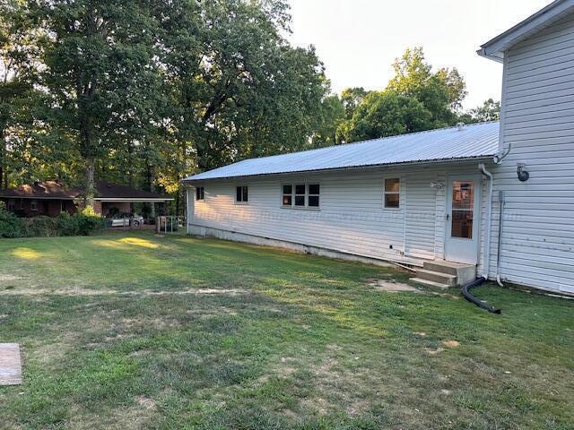 1807 30th St, Haleyville, AL 35565 - back of house with a yard and metal roof