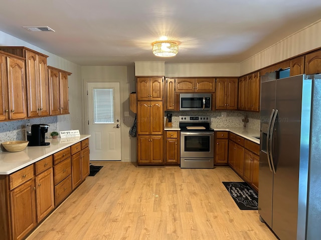 1728 Primrose Dr, Cullman, AL 35055 - kitchen featuring appliances with stainless steel finishes, light wood-type flooring, light countertops, and tasteful backsplash