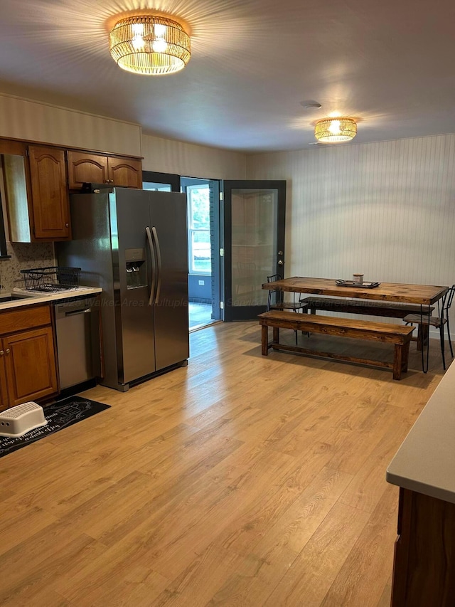 1728 Primrose Dr, Cullman, AL 35055 - kitchen featuring appliances with stainless steel finishes, light wood-type flooring, brown cabinetry, light countertops, and a sink