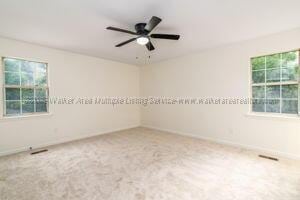 6370 Ball Rd, Mount Olive, AL 35117 - carpeted empty room with plenty of natural light, a ceiling fan, and baseboards