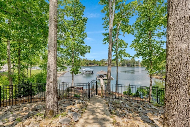 property view of water featuring fence and a dock
