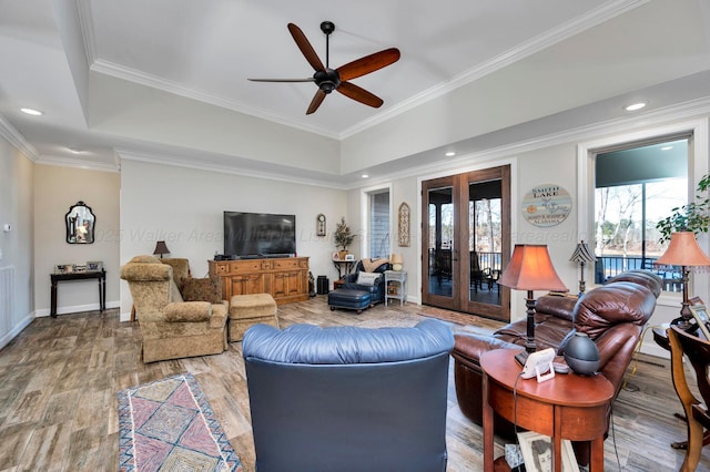 living room with ceiling fan, french doors, baseboards, wood finished floors, and ornamental molding