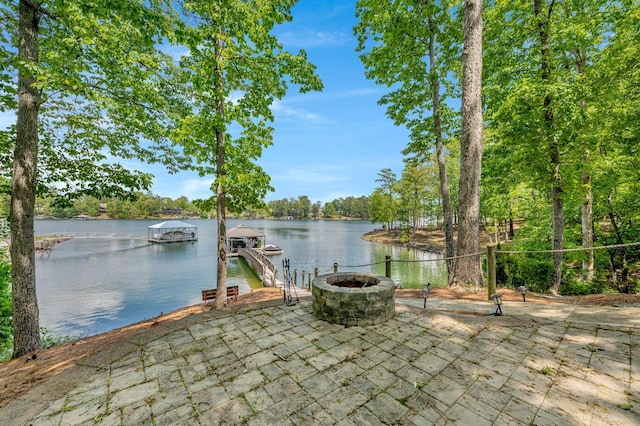 exterior space with a water view, a dock, and an outdoor fire pit