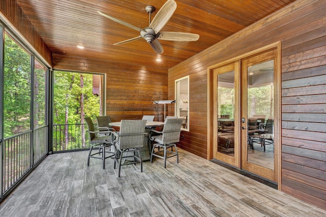 sunroom / solarium with ceiling fan, french doors, and outdoor dining space