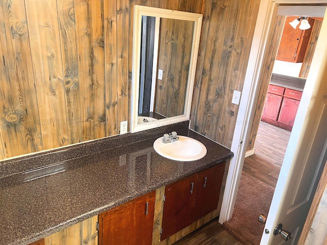 bathroom with vanity, wood-type flooring, and wood walls