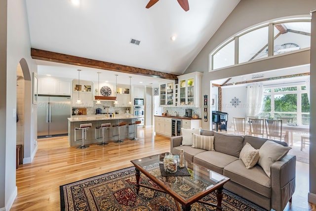 662 Sipsey Pike, Double Springs, AL 35553 - living area with arched walkways, light wood finished floors, beverage cooler, a ceiling fan, and bar