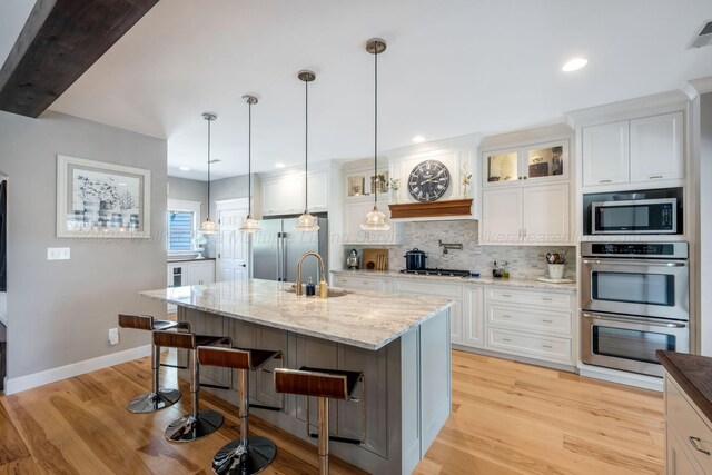 662 Sipsey Pike, Double Springs, AL 35553 - kitchen with stainless steel appliances, light wood finished floors, tasteful backsplash, a sink, and baseboards