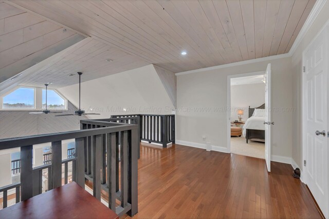 hall featuring baseboards, ornamental molding, wood finished floors, and wooden ceiling
