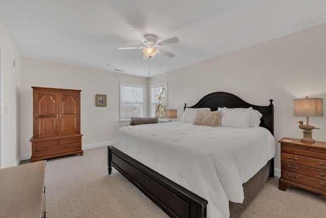 bedroom with visible vents, baseboards, light colored carpet, and ceiling fan