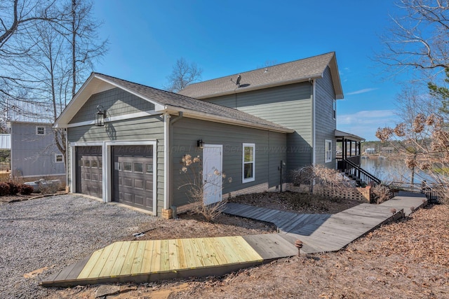 back of house featuring driveway, stairs, and a garage