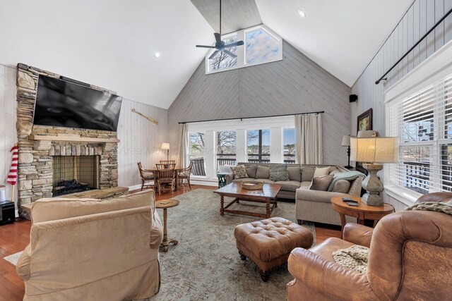 living room featuring a fireplace, high vaulted ceiling, ceiling fan, and wood finished floors