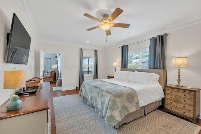 bedroom with baseboards, crown molding, wood finished floors, and ceiling fan