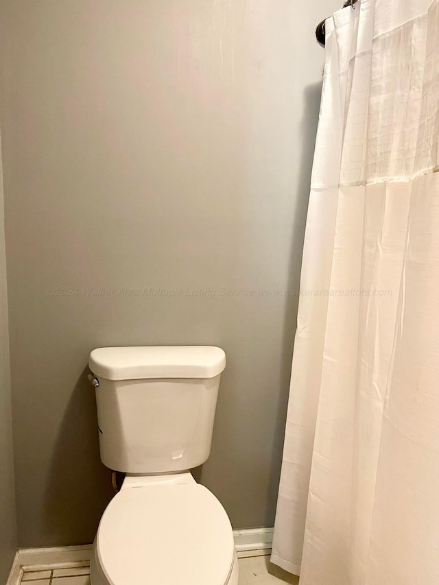full bathroom with baseboards and toilet