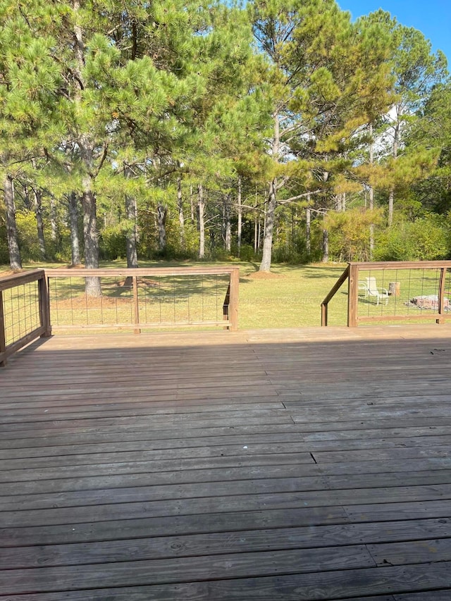 wooden deck with a yard and view of wooded area