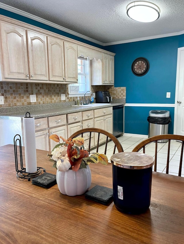 kitchen featuring a sink, dishwasher, decorative backsplash, a textured ceiling, and crown molding