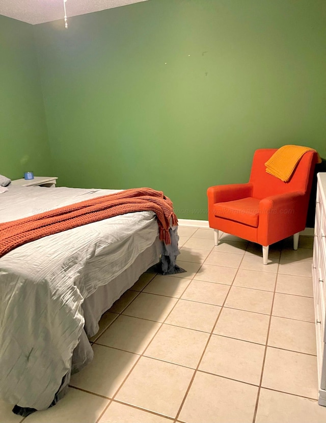 bedroom with light tile patterned floors and baseboards