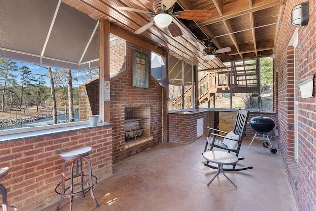 view of patio featuring an outdoor brick fireplace, stairway, and ceiling fan