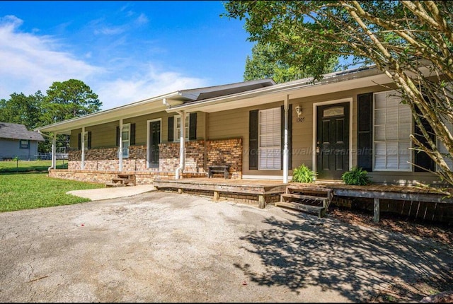 ranch-style house with covered porch and a front lawn