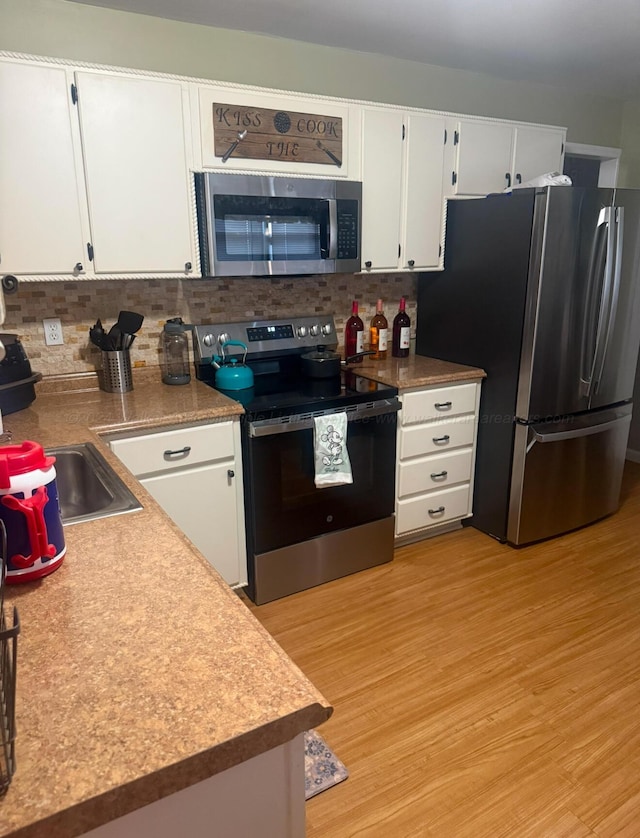 kitchen featuring white cabinetry, light wood-type flooring, and stainless steel appliances